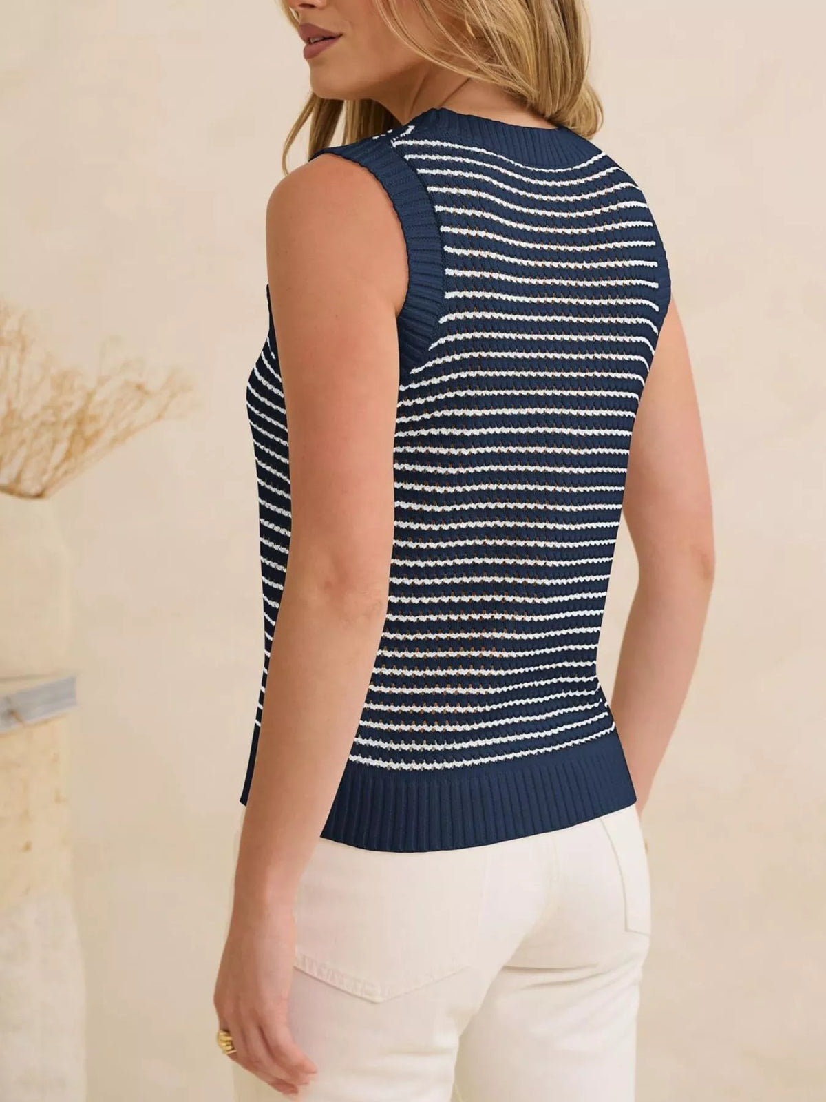 Striped knit sweater vest by Plush Fashion Hub, featuring a fitted design with colorful horizontal stripes on soft fabric.