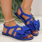Shopimist bow embellished flat sandals featuring stylish straps and decorative bow accents on a comfortable flat sole.