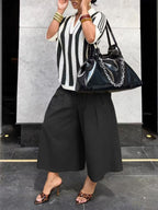 Women's wide-leg cargo pants by Plush Fashion Hub with zipper and button details, featuring a relaxed, stylish fit.