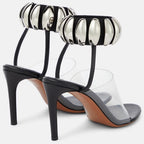 Clear PVC open-toe stilettos with black heels, insoles, and metallic silver bead-embellished ankle cuffs.