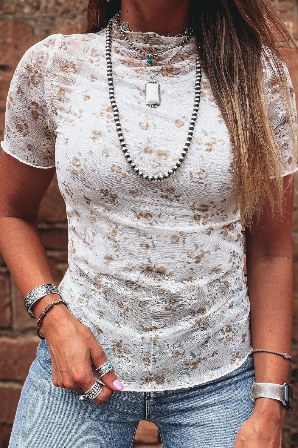 White floral lace fitted mock neck T-shirt with short sleeves from Trendsi, featuring intricate lace detailing and a sleek, feminine fit.