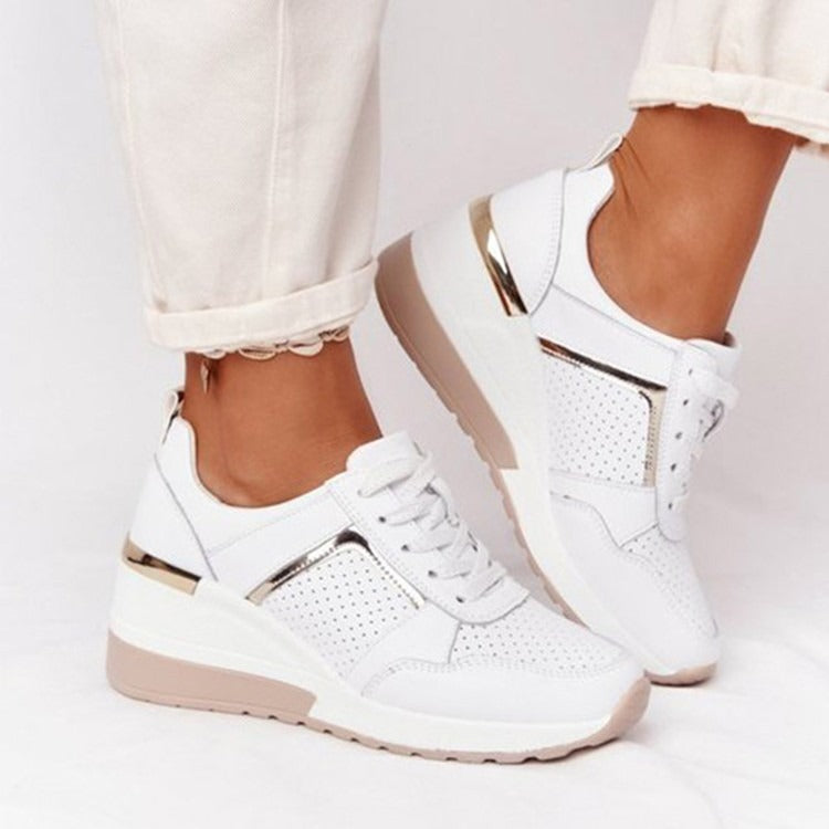 White lace-up platform sneakers with perforated mesh details, metallic gold accents, and a beige rubber sole.