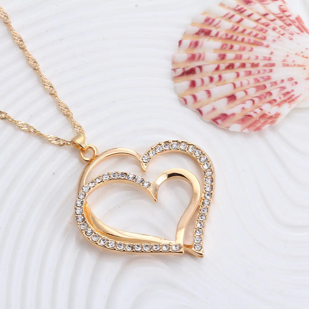 Double heart earrings and matching necklace wedding set with silver-tone jewelry featuring delicate heart designs.