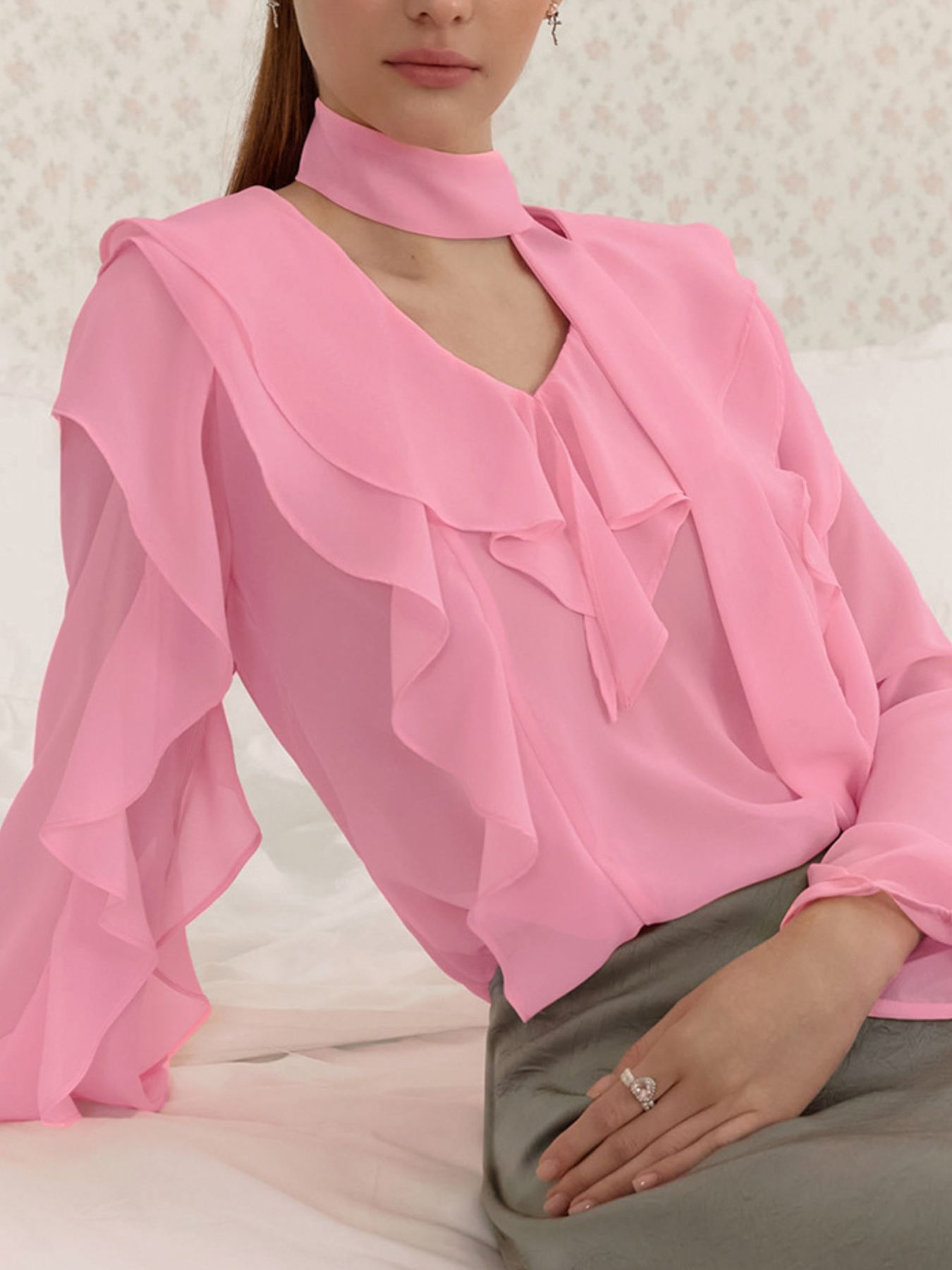 Elegant chiffon blouse with ruffle trim and tie neck detail, featuring a flowy, lightweight fabric and feminine design.