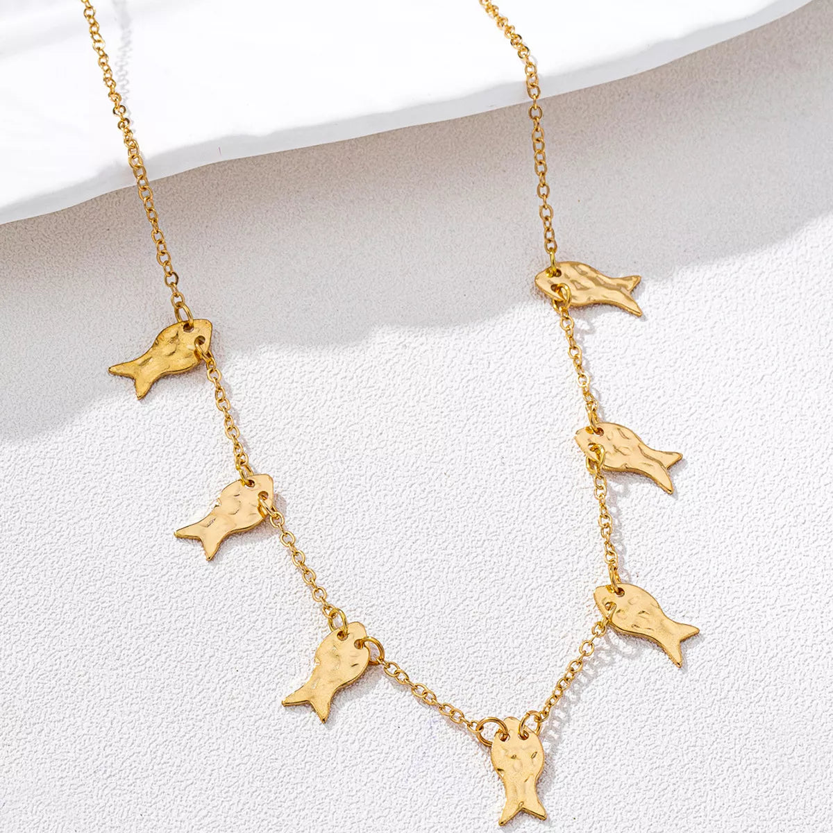 18K gold-plated fish charm necklace with delicate chain, featuring a shiny fish pendant, styled for elegant jewelry looks.