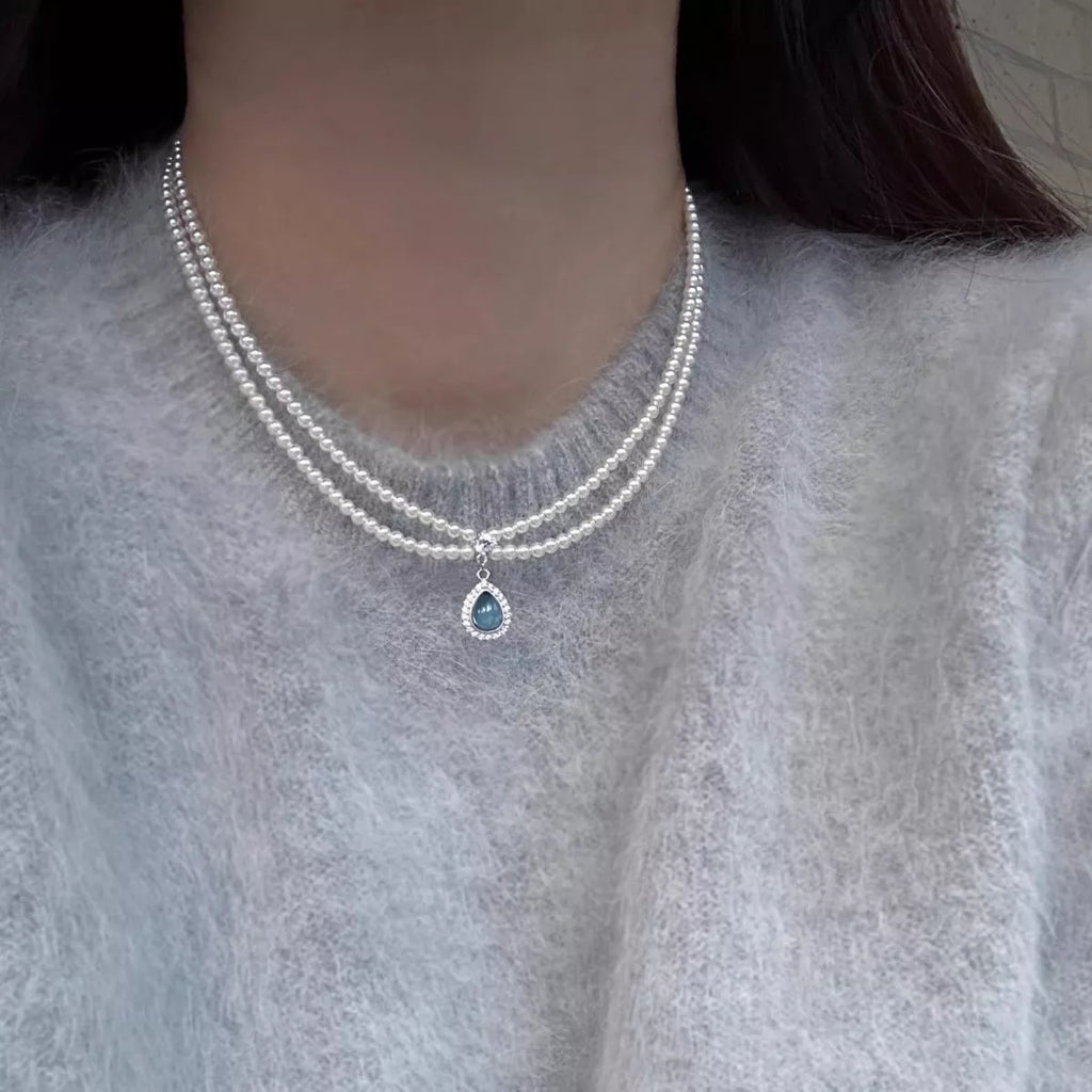 Double layered pearl necklace by Shopimist with teardrop pendant, showcasing elegant white pearls and a dangling teardrop charm.