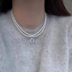 Double layered pearl necklace by Shopimist with teardrop pendant, showcasing elegant white pearls and a dangling teardrop charm.