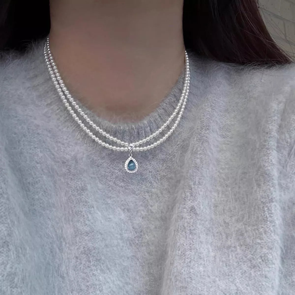 Double layered pearl necklace by Shopimist with teardrop pendant, showcasing elegant white pearls and a dangling teardrop charm.