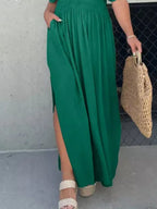 Plus size maxi dress by Trendsi featuring a slit V-neck, smocked waist, and full-length design, perfect for elegant summer wear.