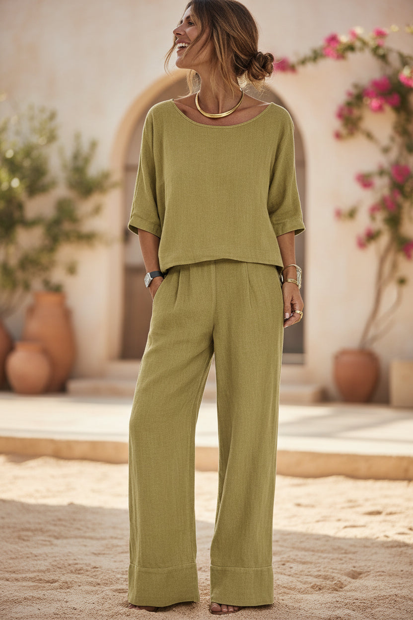 Women's resort set by FitiqueFit with short sleeve top and wide-leg pants, shown in a relaxed, stylish outdoor setting.