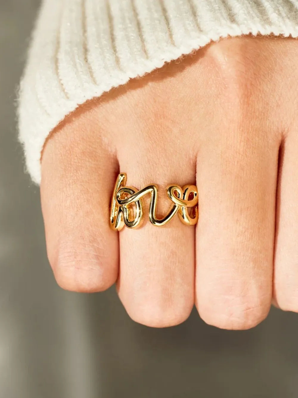 Love 18K gold-plated sterling silver ring with a sleek band and minimalist design, showcasing polished silver and gold accents.