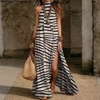 Women's printed halterneck split maxi dress by Plush Fashion Hub, sleeveless, loose fit with colorful floral pattern.