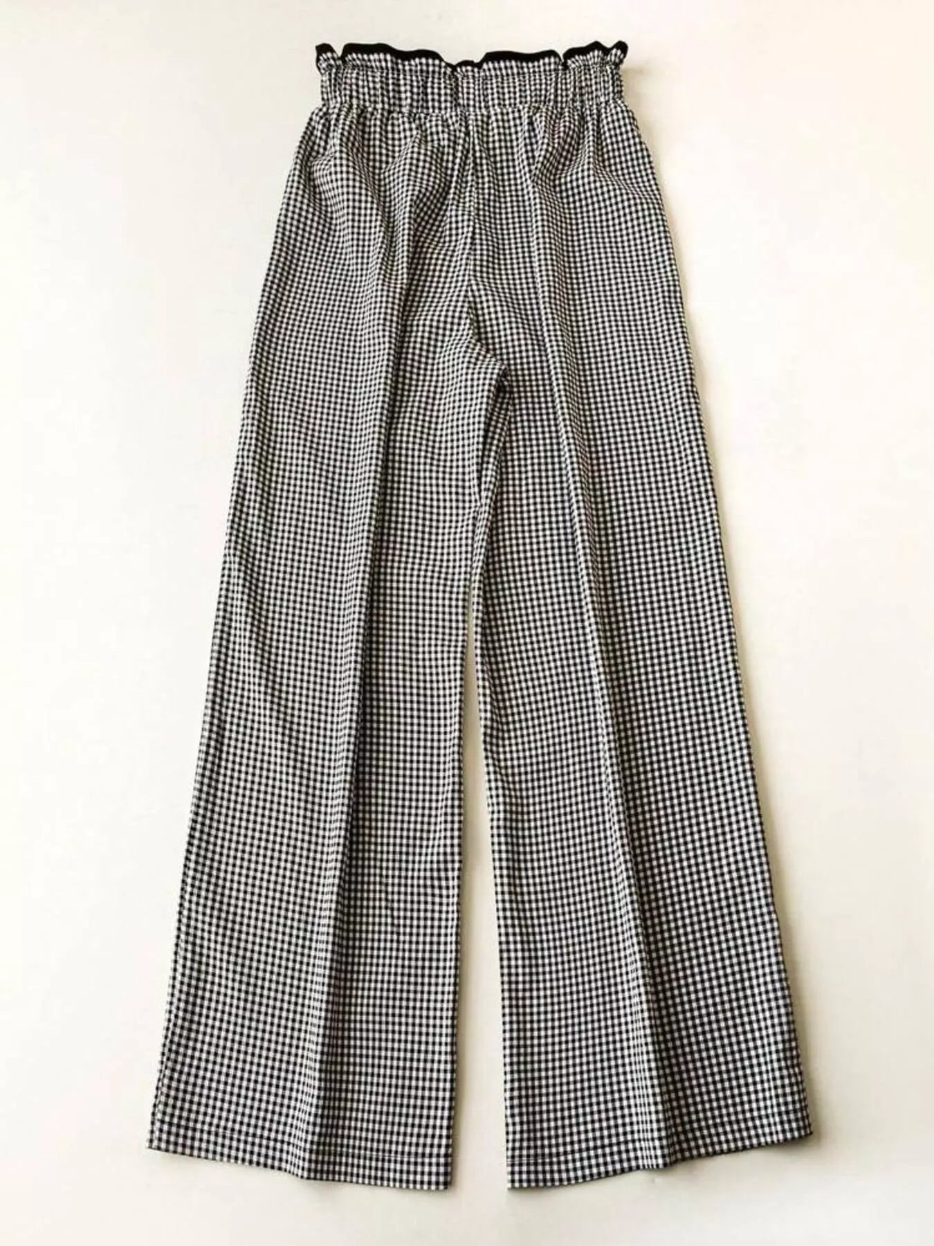 Women's high-waisted gingham wide-leg pants with pockets, trendy fashion pants from Trendsi, shown in black and white checkered pattern.