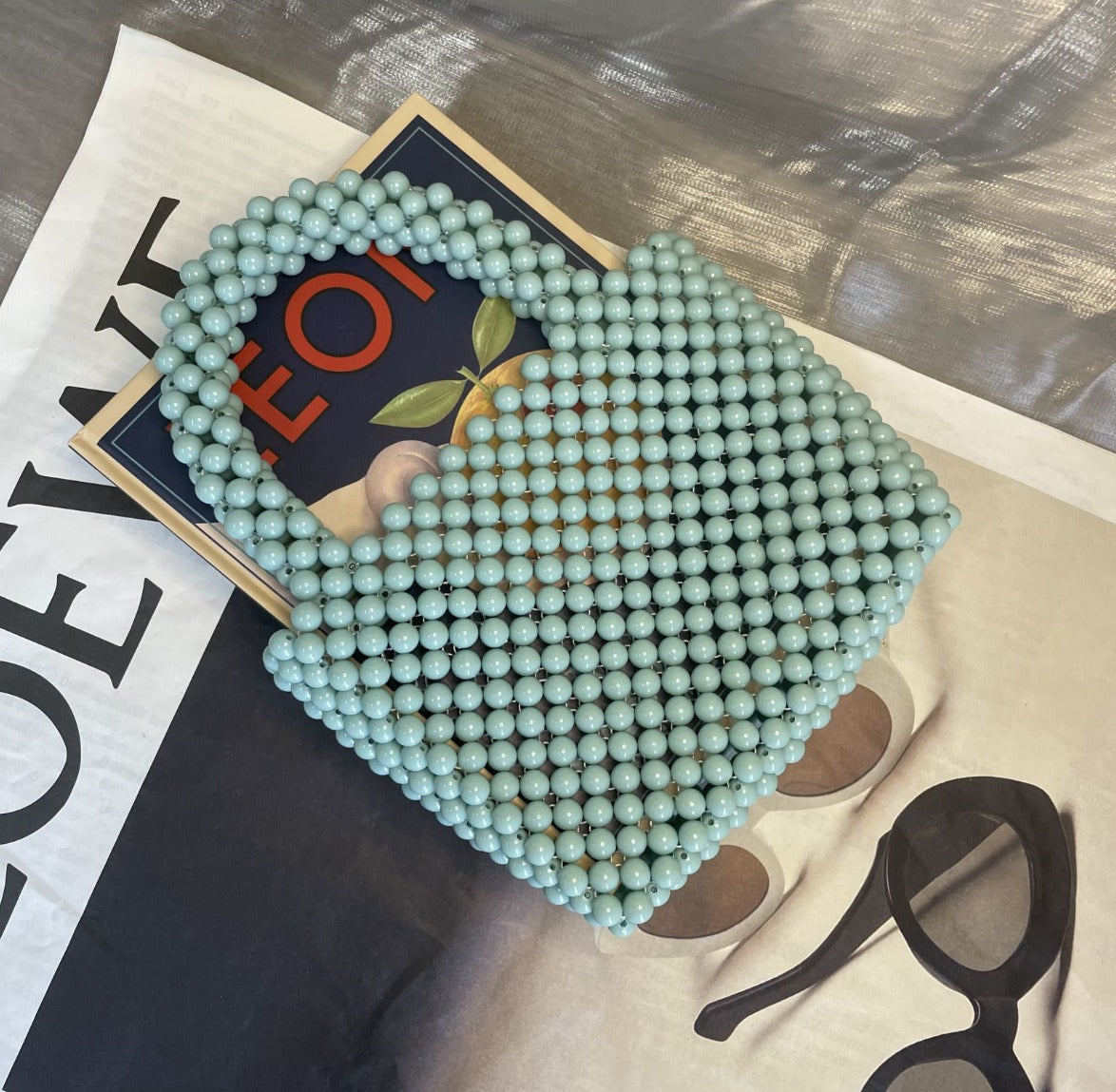 Eprolo beaded handbag with solid color design, featuring intricate beadwork and a stylish, compact handbag shape.
