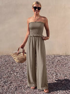 Plush Fashion Hub smocked strapless wide-leg jumpsuit, stylish and comfortable, shown in a flat-lay image with soft fabric details.