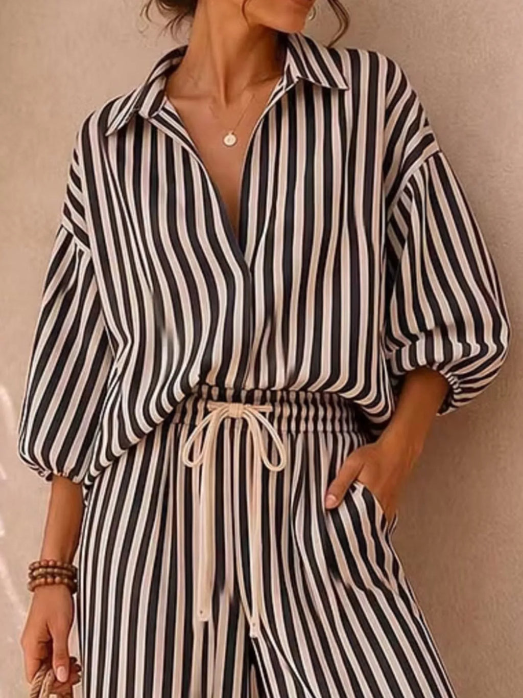Plus size striped puff sleeve shirt and wide-leg drawstring pants set by Trendsi, featuring a coordinated full-length top and pants.