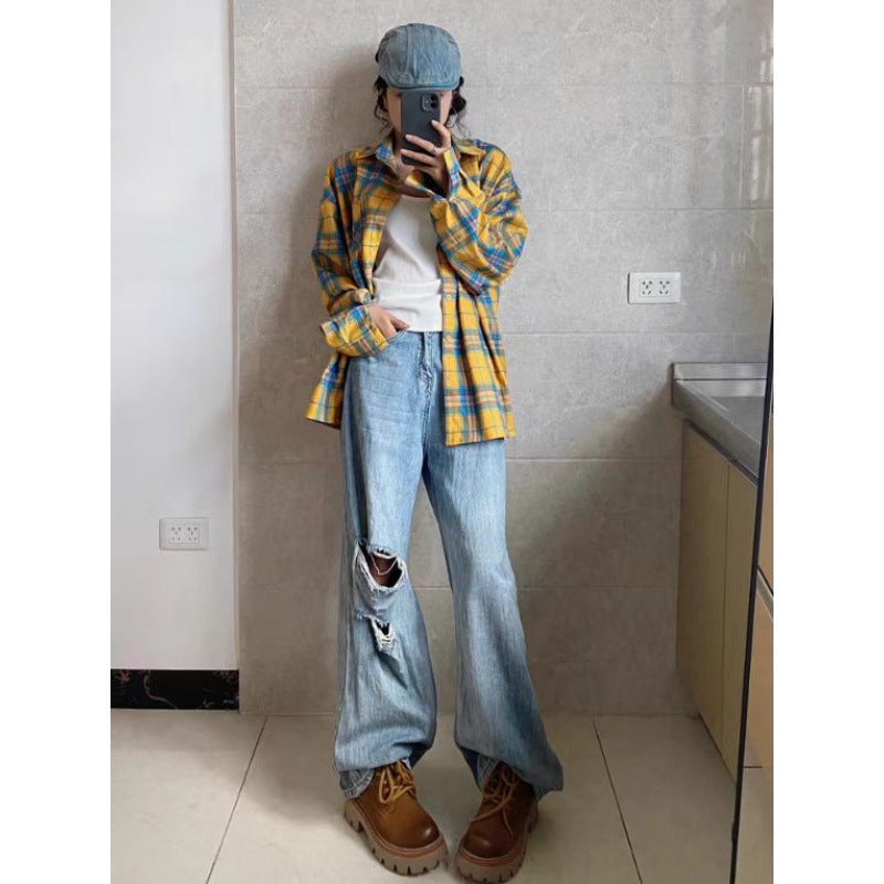 A yellow and blue plaid cotton flannel shirt worn over a white top and distressed light blue denim jeans.