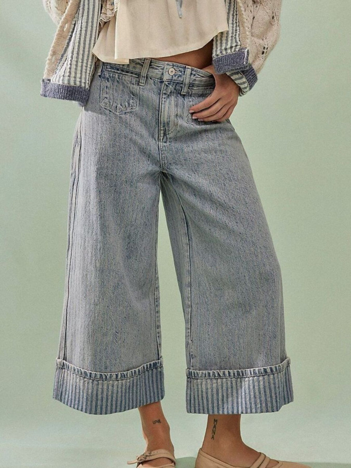 Plush Fashion Hub wide-leg cropped denim jeans with distressed details and classic blue wash, displayed on a hanger.