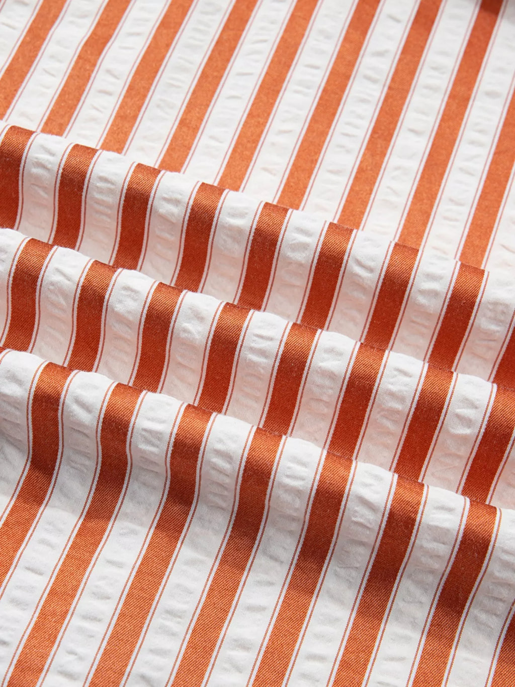 Stripe pinched V-neck mini dress with turn-up cuffs and pockets by Plush Fashion Hub, featuring a stylish striped pattern and fitted silhouette.
