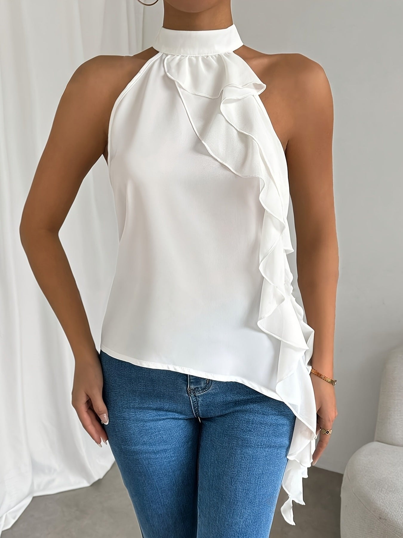 Elegant white sleeveless blouse with ruffle halter neck designed for women, ideal as a chic office top from Trendsi.