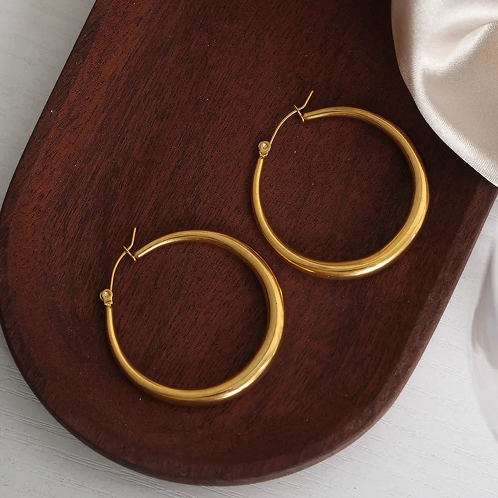 18K gold-plated hoop earrings with a sleek, polished finish, showcasing classic hoop design on a plain background.
