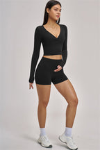Fitglutes Activewear Swoon long sleeve crop top, black with fitted design and thumbhole cuffs, ideal for gym and workout sessions.