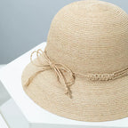 Woven straw bucket hat with decorative band from Plush Fashion Hub, featuring a wide brim and stylish design for sun protection.