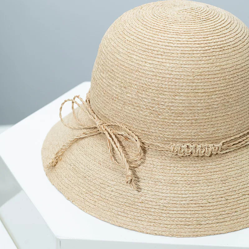 Woven straw bucket hat with decorative band from Plush Fashion Hub, featuring a wide brim and stylish design for sun protection.