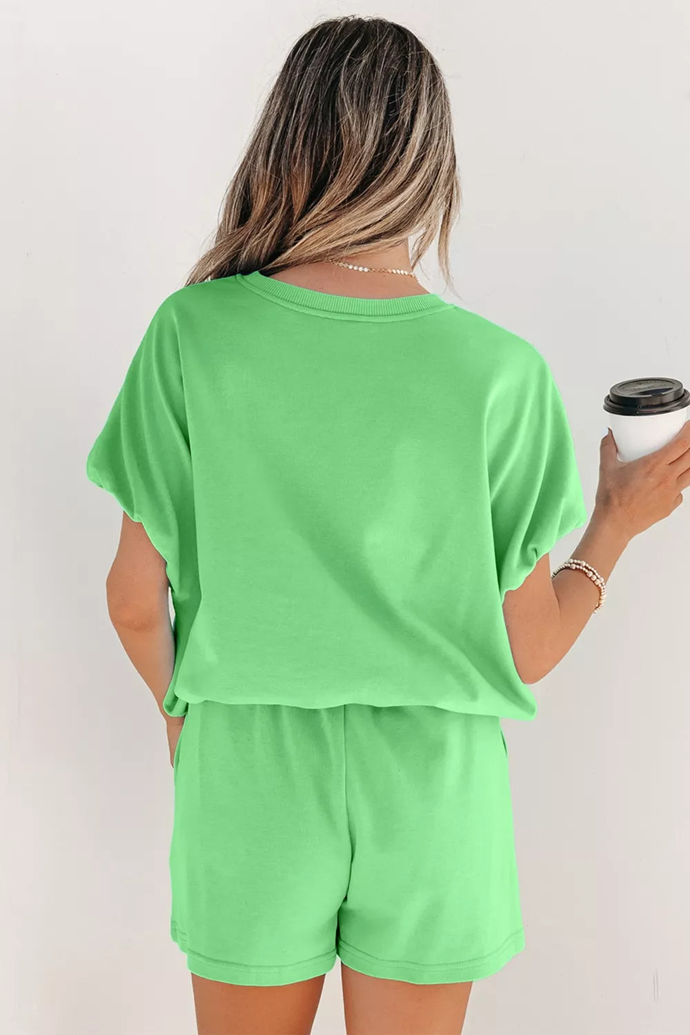 Pair of trendy solid color puffy loose top drawstring shorts from Trendsi, shown with stylish rings on a model.