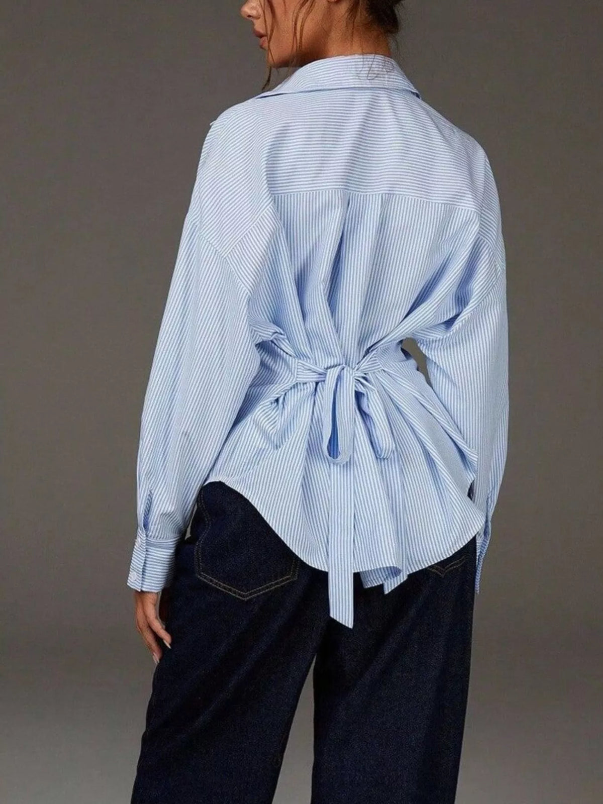Casual striped button-down shirt from Trendsi featuring a classic collar, long sleeves, and a relaxed fit in blue and white stripes.