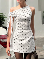 Polka dot sleeveless mini dress with bow accents from Shopimist, featuring a fitted bodice and playful pattern.