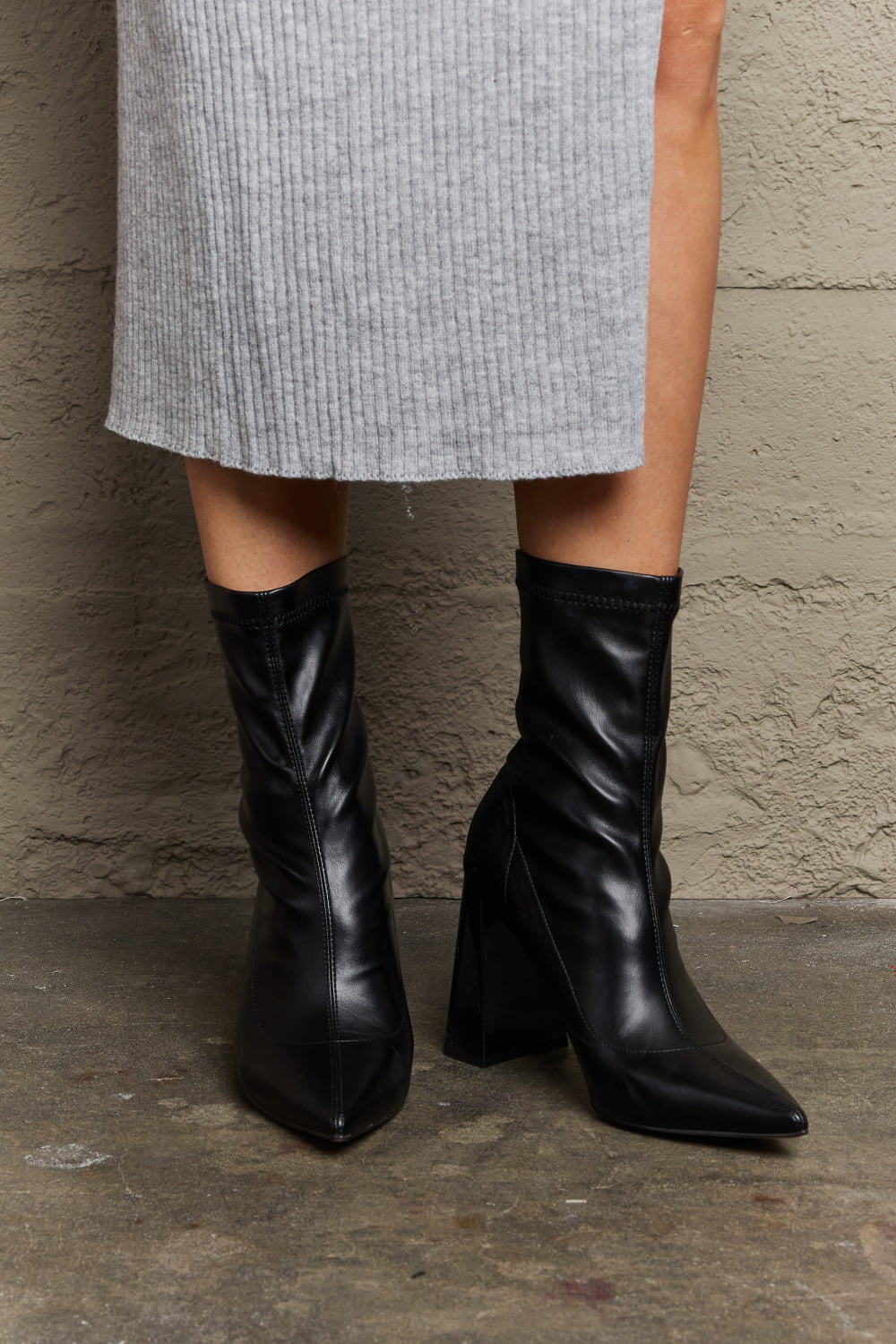 Weeboo Stacy block heel sock boots featuring black fabric, snug fit, and stylish ankle-length design by Trendsi.