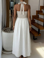 Elegant two-tone halter neck maxi dress with ruched details and pockets by Plush Fashion Hub, shown on a model.
