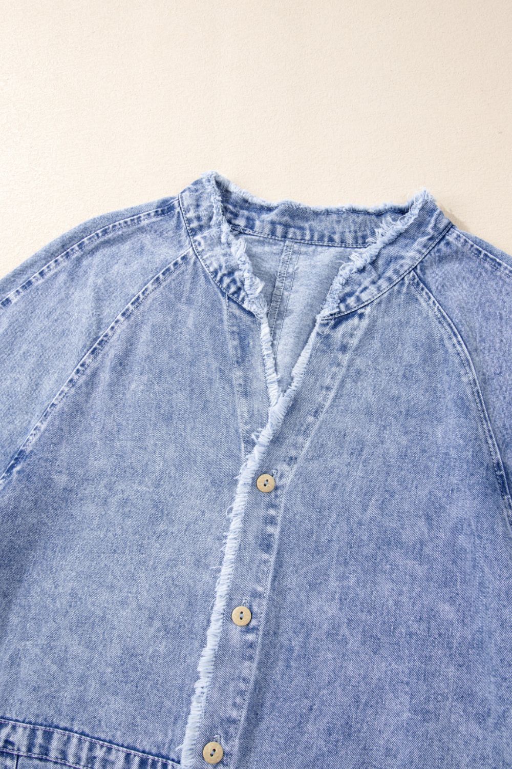VYSN raw hem button-down long sleeve denim dress hanging on a rack, showcasing casual fashion style and distressed details.