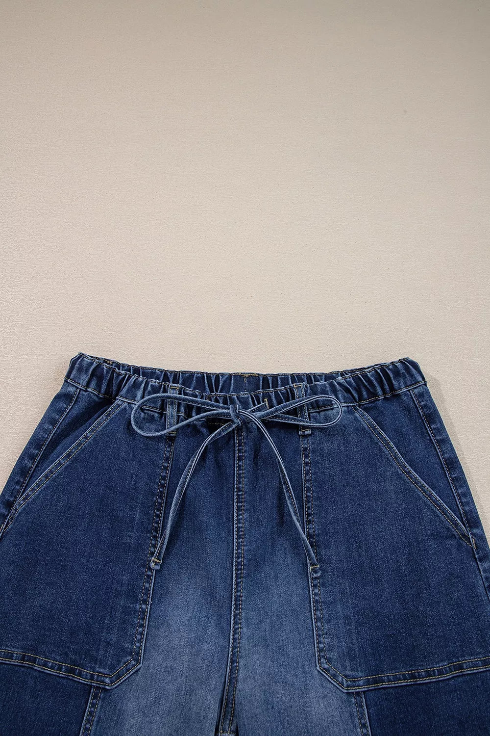 Wide-leg denim pants with drawstring, seam details, and raw hem by Plush Fashion Hub, shown in a stylish casual fit.