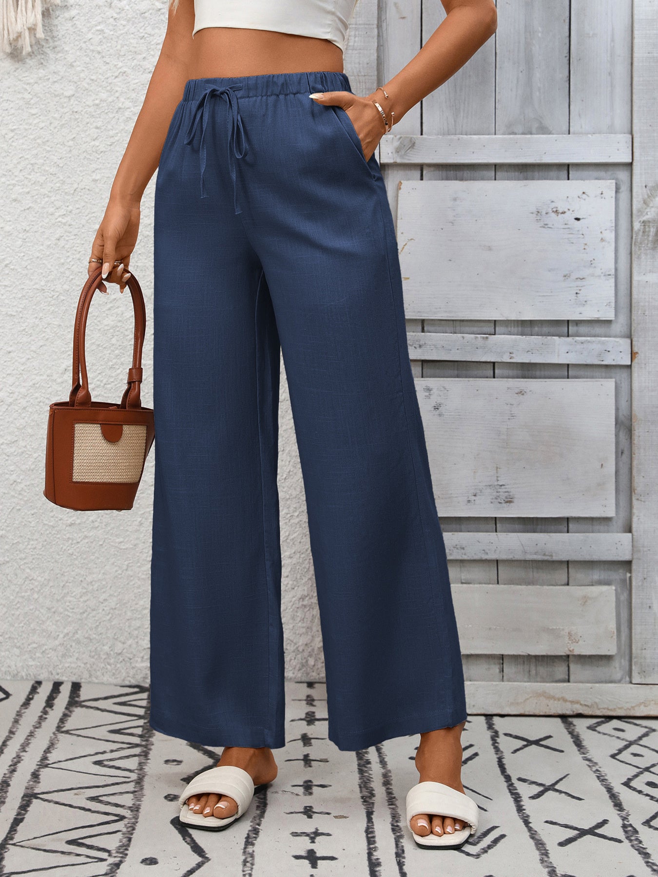 Women's high-waisted wide-leg drawstring pants in soft breathable viscose, showing relaxed fit and stylish design.