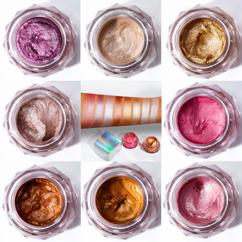 Grid of eight faceted plastic jars with metallic, shimmer eyeshadows in purple, gold, copper, and pink shades.