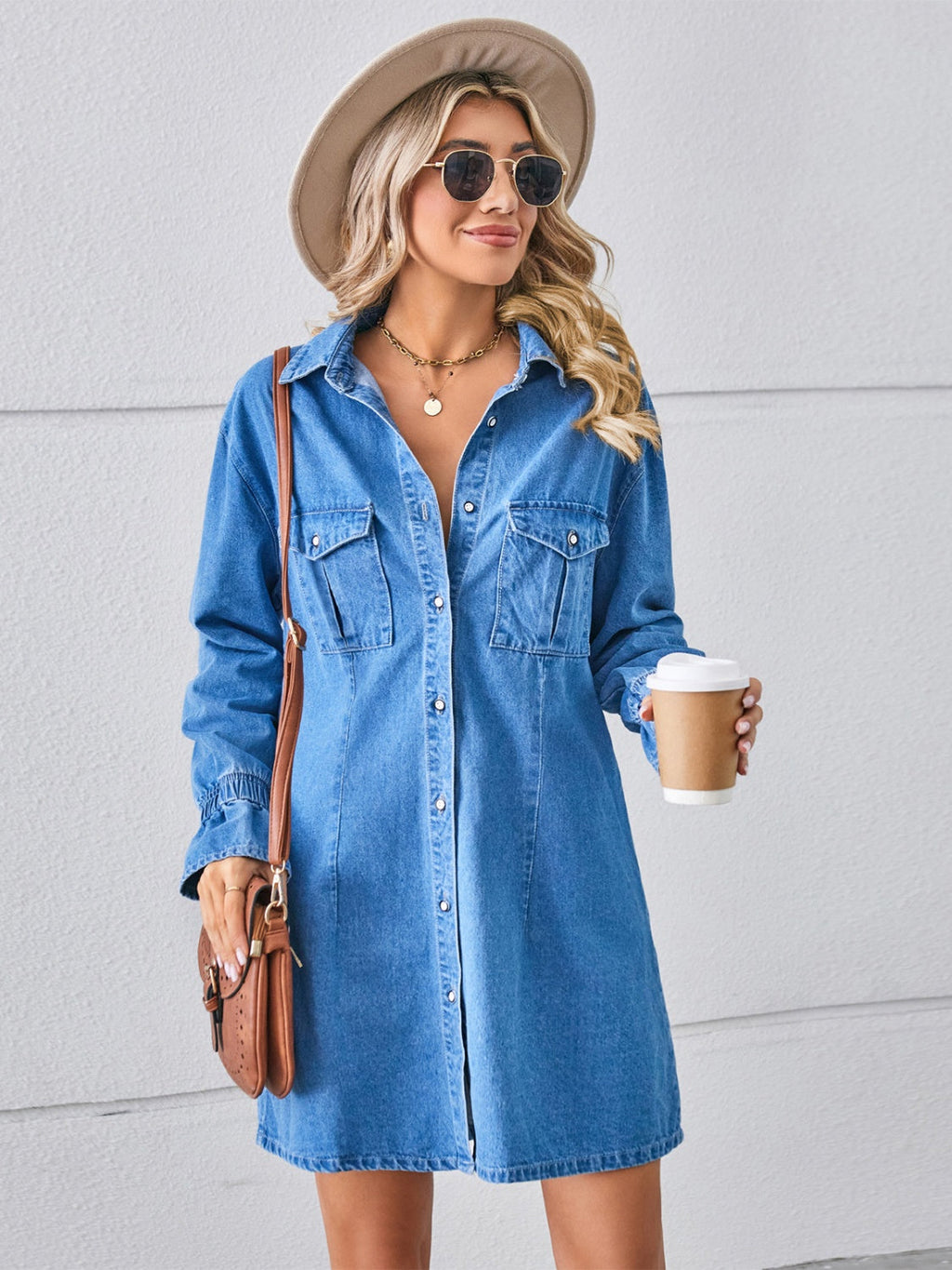 VYSN pocketed dropped shoulder mini denim dress displayed on a hanger, showcasing its casual style and classic blue denim fabric.