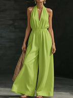 Plush Fashion Hub women's V-neck halter neck jumpsuit with sleeveless design, fitted waist, and wide-leg pants.
