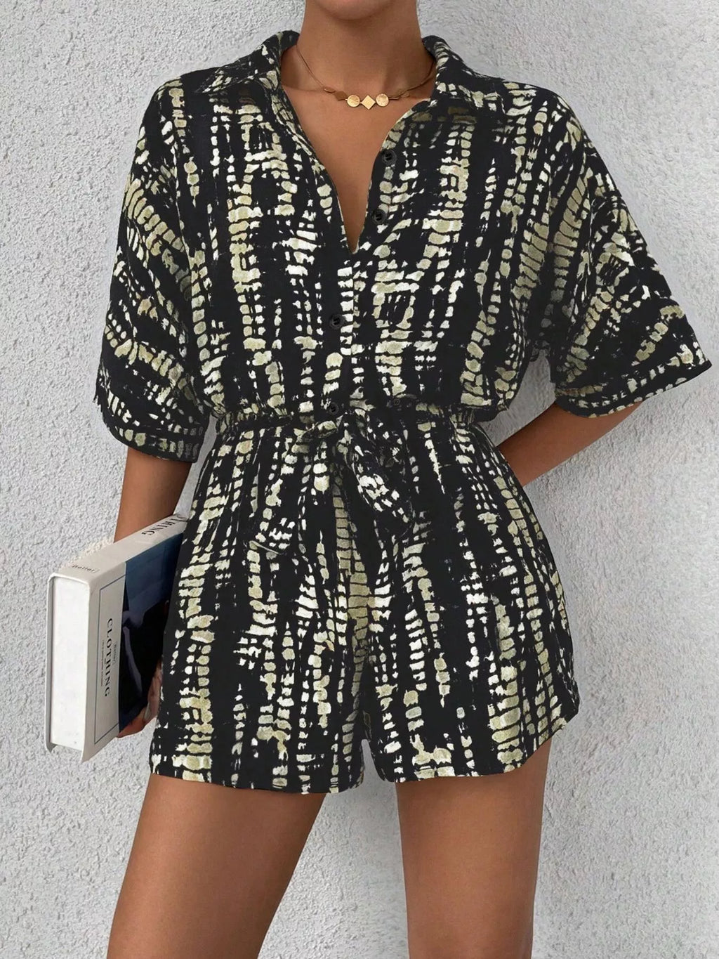 Striped button-up belted romper jumpsuit by Trendsi, featuring a stylish design with a waist belt and button details.