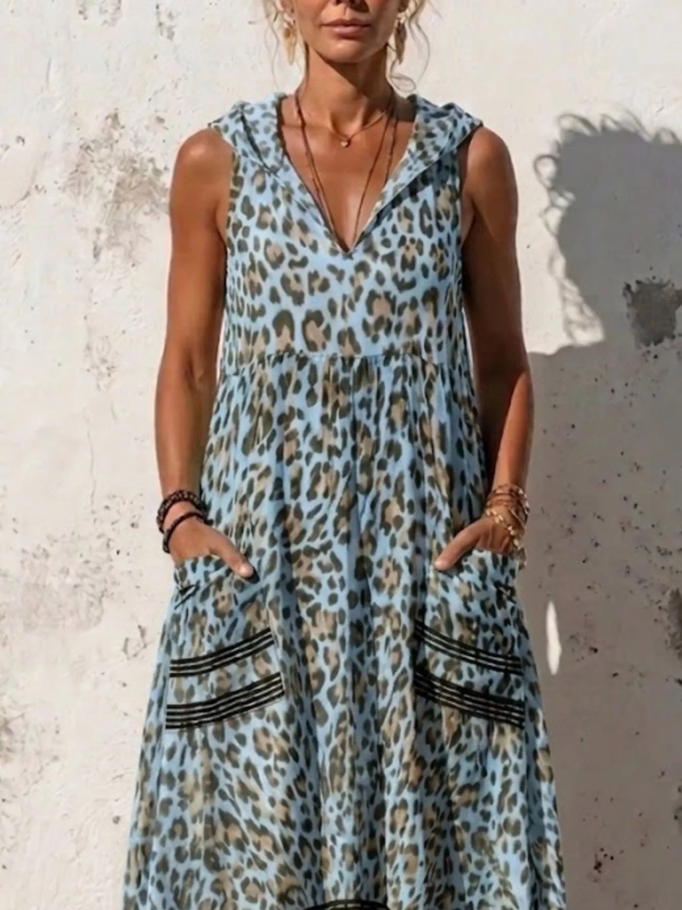 Plus size leopard print sleeveless hooded maxi dress with pockets by Trendsi, featuring a full-length design and stylish hood.