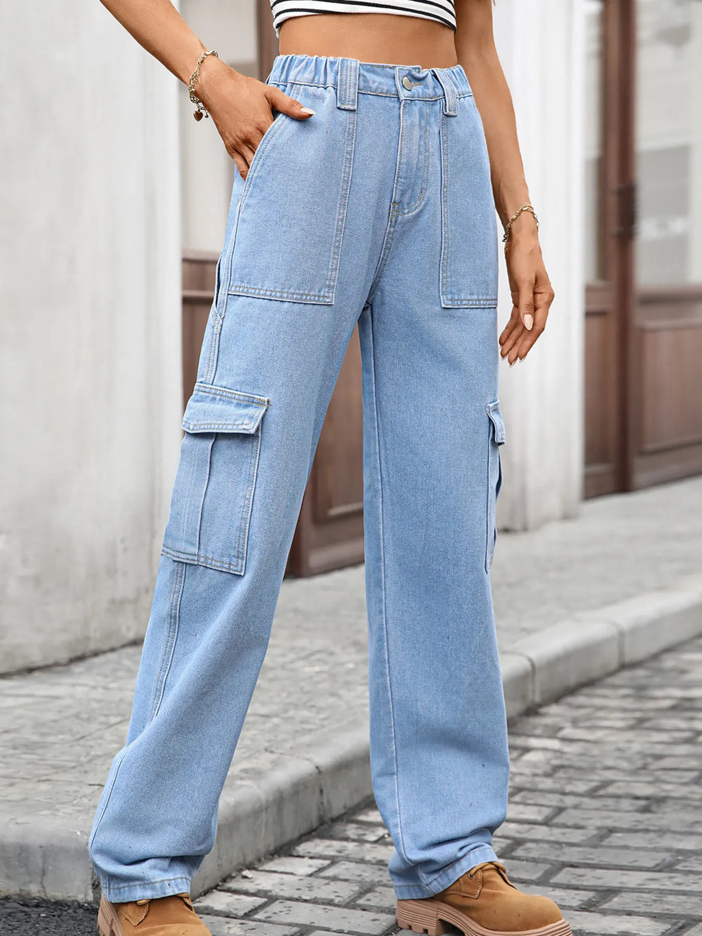 High-waisted cargo denim jeans by Plush Fashion Shop featuring multiple pockets and a relaxed fit on a model.