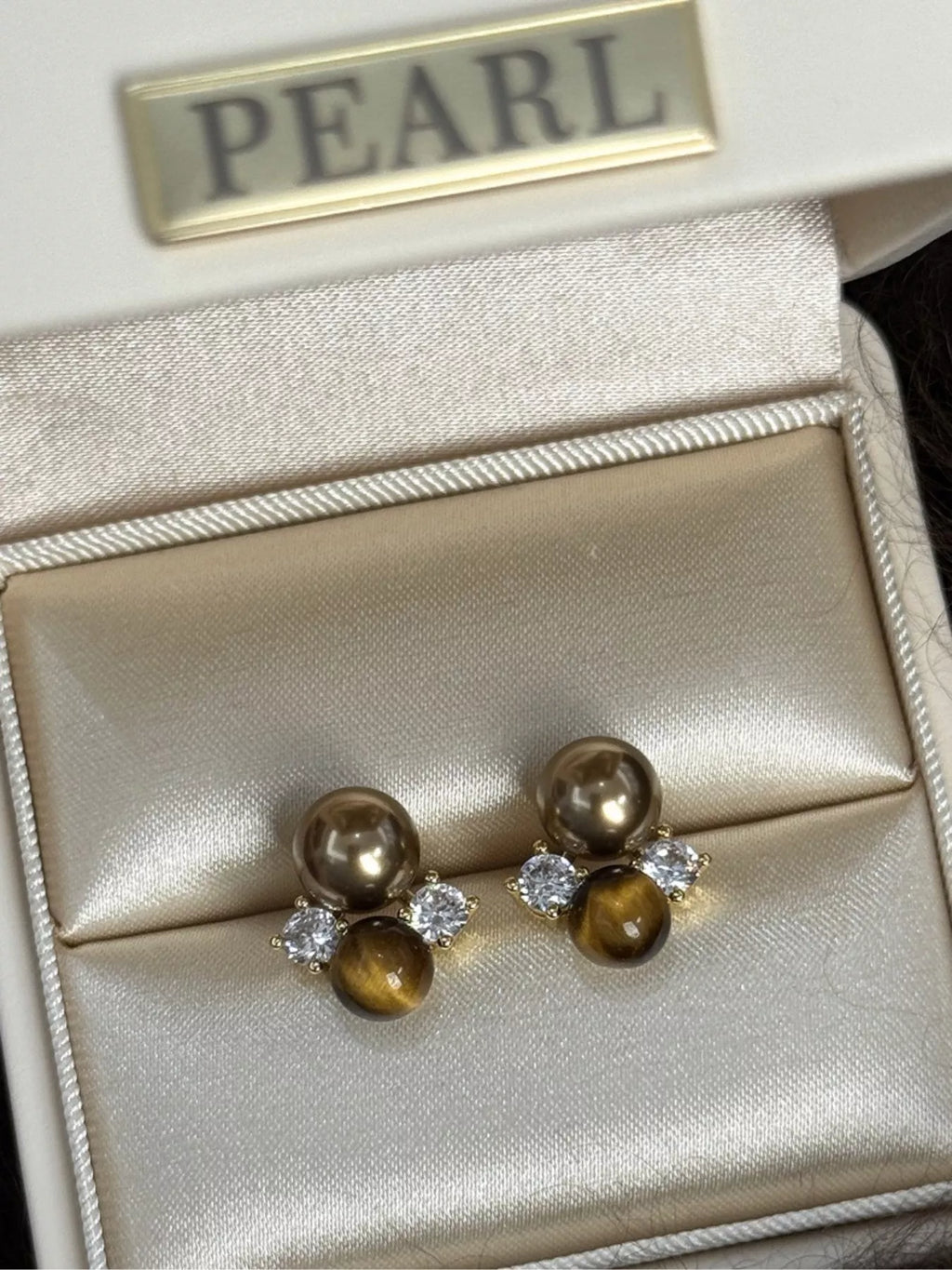 Tiger Eye stud earrings featuring polished, oval-shaped gemstones set in silver-tone metal, stylish and versatile jewelry accessory