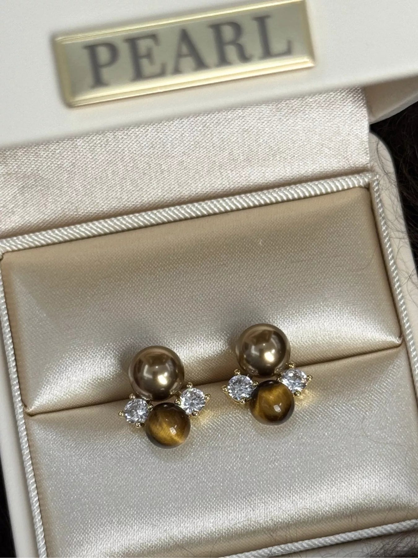 Tiger Eye stud earrings featuring polished, oval-shaped gemstones set in silver-tone metal, stylish and versatile jewelry accessory