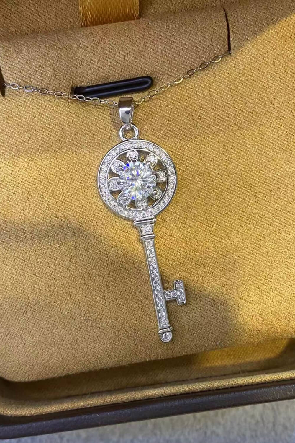 Platinum plated key pendant necklace with 1 carat moissanite, featuring a sparkling gemstone on a delicate chain.