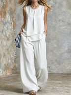 Women's sleeveless two-piece set with solid color wide-leg pants and matching top from Plush Fashion Hub, shown on a model.