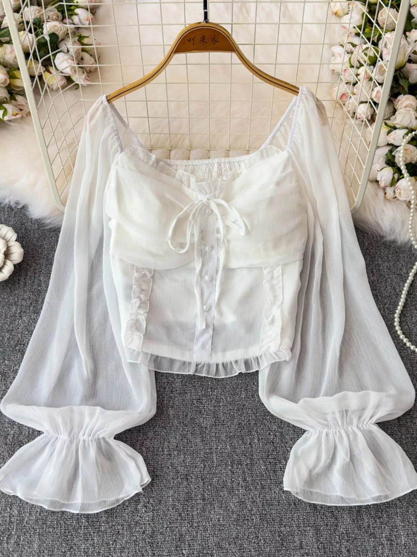 Women's elegant frill flounce sleeve smocked blouse in lightweight polyester, showcased on a dress form with detailed sleeve design.