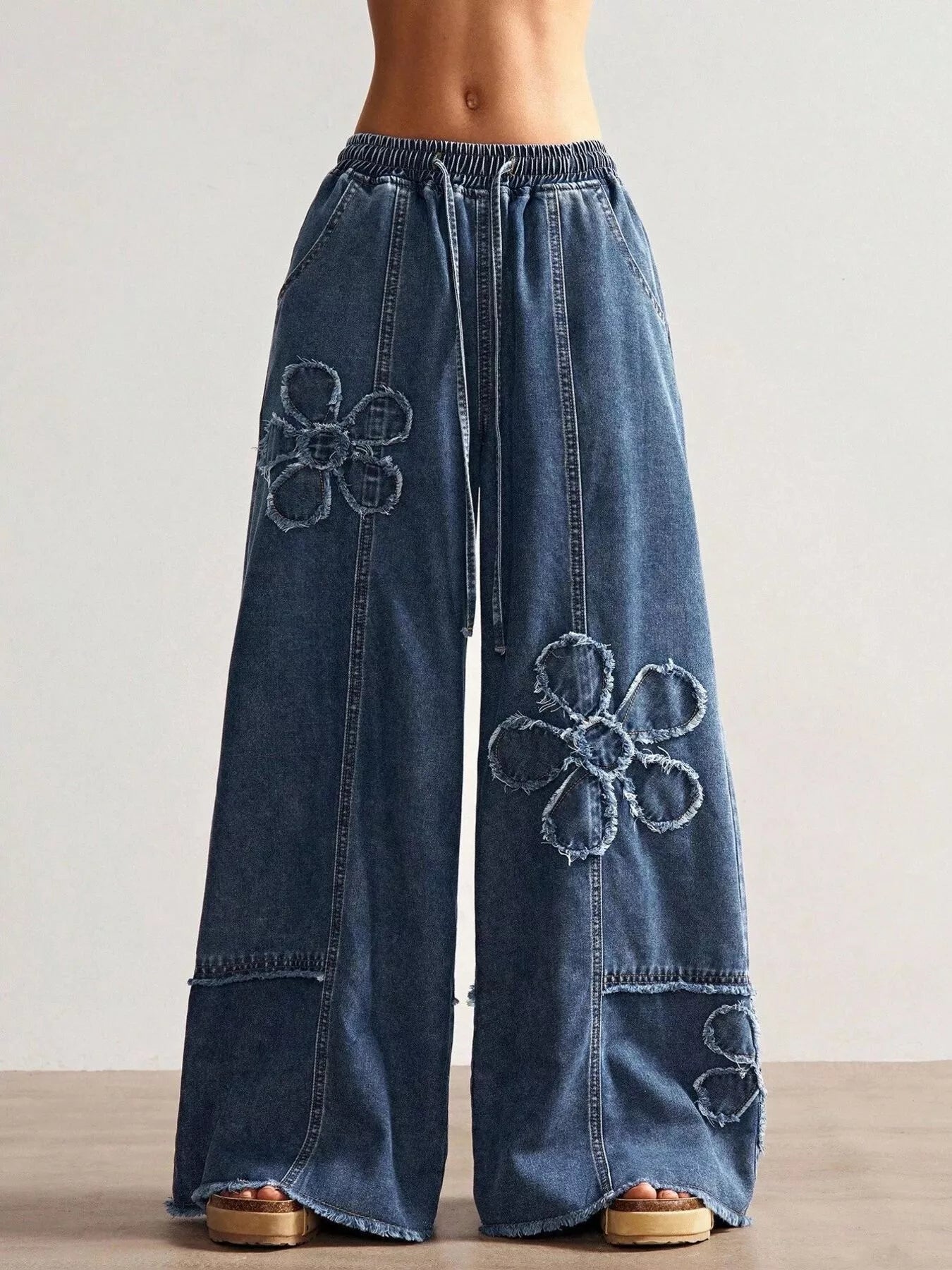 Shopimist floral appliques wide leg jeans with decorative floral patches, relaxed fit, and stylish design on light denim fabric.