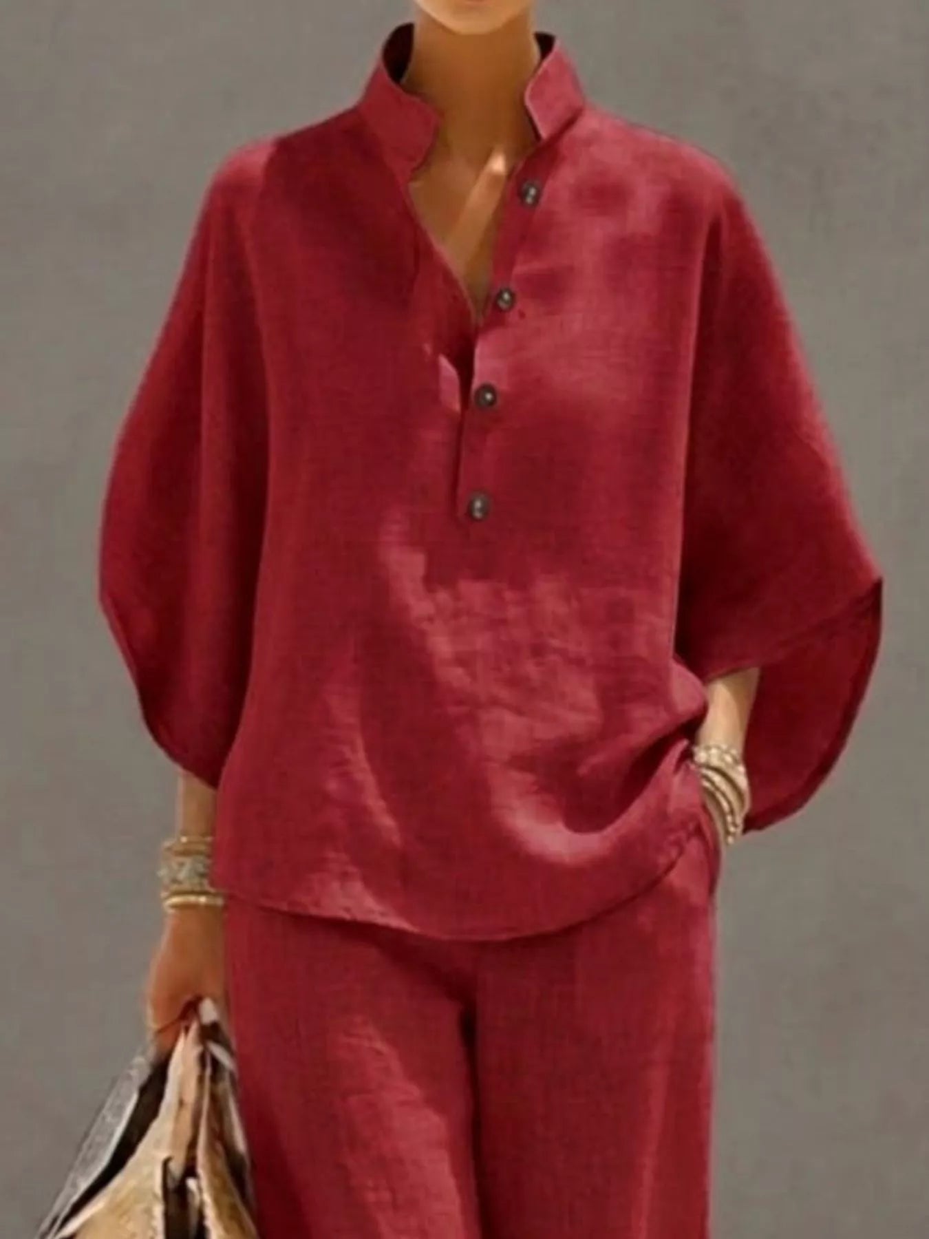 Plus size women's two-piece dress set with button details and 3/4 sleeves, featuring a top and matching pants from Trendsi.