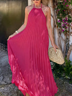 Elegant black halter neck pleated backless maxi dress for formal events, featuring flowing fabric and sophisticated design.